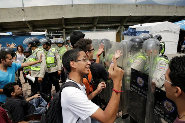 Demonstrators shout slogans in front of riot police during a student rally demanding a referendum to remove Venezuela's President Nicolas Maduro in Caracas, Venezuela October 24, 2016. (Photo by Marco Bello/Reuters)