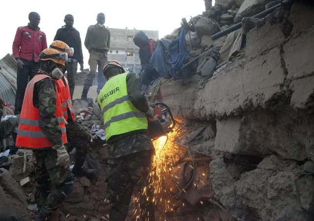 A rescue worker cuts the iron rods on the site of the collapsed building in the capital Nairobi, Kenya, Monday, January 5, 2015. (Photo by Sayyid Azim/AP Photo)