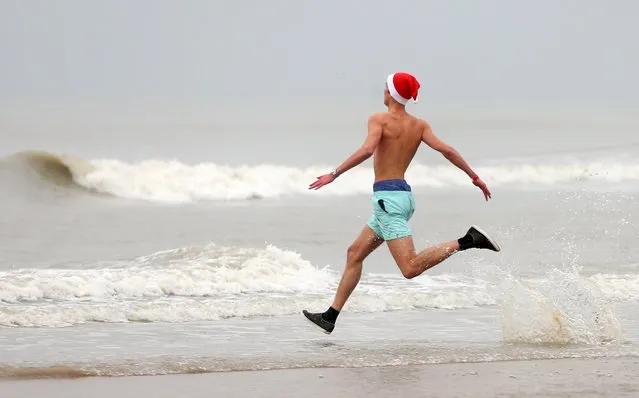 A participant runs towards the waters of the North Sea during the annual New Year's swim event in Ostend, Belgium January 3, 2015. The temperature of the water was eight degrees Celsius (46.4 degrees Fahrenheit). (Photo by Francois Lenoir/Reuters)