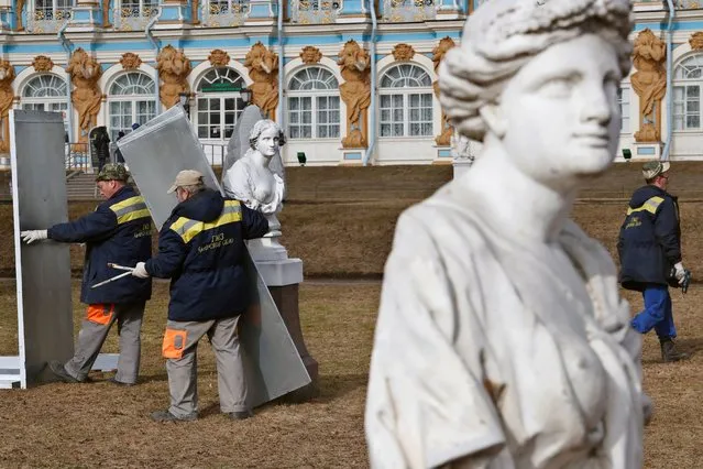 Museum workers open protective wooden crates of Venetian marble statues after wintering on the Hermitage Alley of the Catherine Park in front of the Catherine Palace in the Tsarskoye Selo museum-reserve in St. Petersburg, Russia, 13 April 2023. The museum-reserve houses 30 sculptures and 11 pedestals. It is one of the largest collections in Russia. The museum will be open to visitors from 15 April through 30 October. (Photo by Anatoly Maltsev/EPA/EFE)