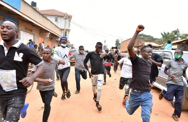 Supporters of Ugandan presidential candidate and singer Robert Kyagulanyi Ssentamu, known as Bobi Wine, run behind his convoy after he cast a ballot in the presidential elections in Kampala, Uganda, January 14, 2021. The 38-year-old reggae artist and lawmaker is channeling the anger of many young Ugandans who say former guerrilla leader Yoweri Museveni, now 76, is an out-of-touch dictator failing to tackle unemployment, corruption and surging public debt. (Photo by Abubaker Lubowa/Reuters)
