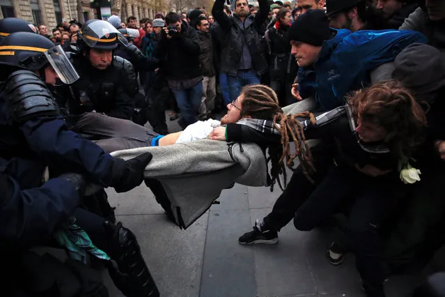 An activist is arrested by riot police officers during a protest ahead of the 2015 Paris Climate Conference at the place de la Republique, in Paris, Sunday, November 29, 2015. (Photo by Thibault Camus/AP Photo)