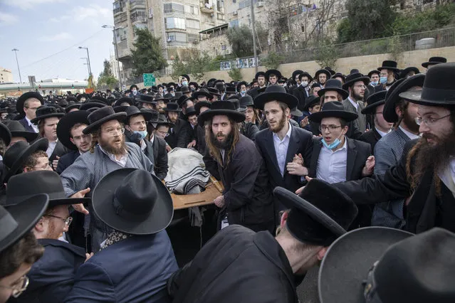 Ultra-Orthodox Jews carry the body of prominent rabbi Meshulam Soloveitchik during his funeral in Jerusalem, Sunday, January 31, 2021. The mass ceremony took place despite the country's health regulations banning large public gatherings, during a nationwide lockdown to curb the spread of the virus. (Photo by Ariel Schalit/AP Photo)