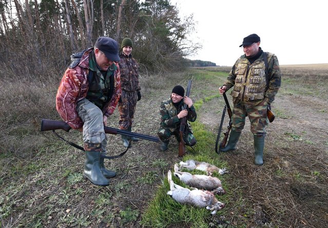 A successful hunter carries out a rite with a gun of an unlucky hunter after a hunt in a field near the village of Novosyolki, Belarus November 5, 2016. (Photo by Vasily Fedosenko/Reuters)