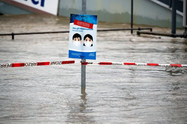 A sign asking people to wear protective face masks against the coronavirus disease (COVID-19) stands near the flooded river Rhine as Europe's most frequented waterway left its banks due to heavy rainfalls over the past few days, in Koenigswinter near Bonn, Germany, February 3, 2021. (Photo by Wolfgang Rattay/Reuters)