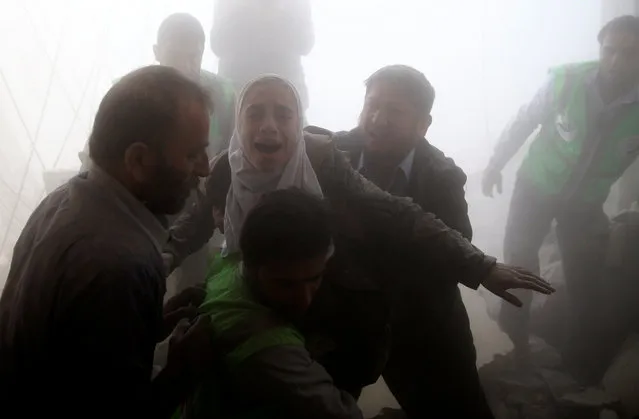 Men evacuate a girl from a site hit by an airstrike in the rebel-held Douma neighbourhood of Damascus, Syria November 7, 2016. (Photo by Bassam Khabieh/Reuters)