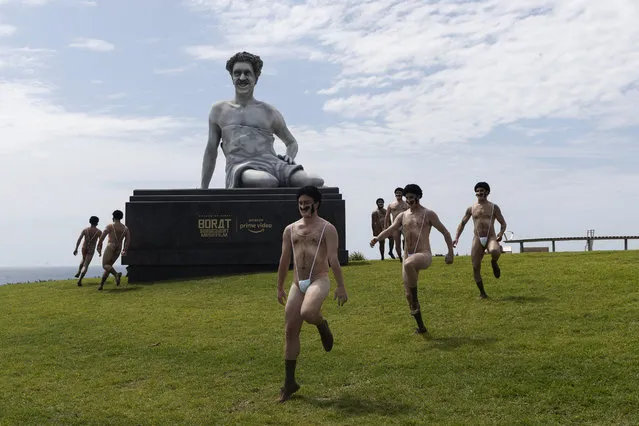 A group of people dressed in “Maskini's” dance around a a six meter high statue of the movie character Borat in Marks Park in Bondi during a press call for the Borat Subsequent Moviefilm on October 22, 2020 in Sydney, Australia. The statue arrived via helicopter, traveling over Sydney's iconic Bondi Beach for the event. (Photo by Brook Mitchell/Getty Images)