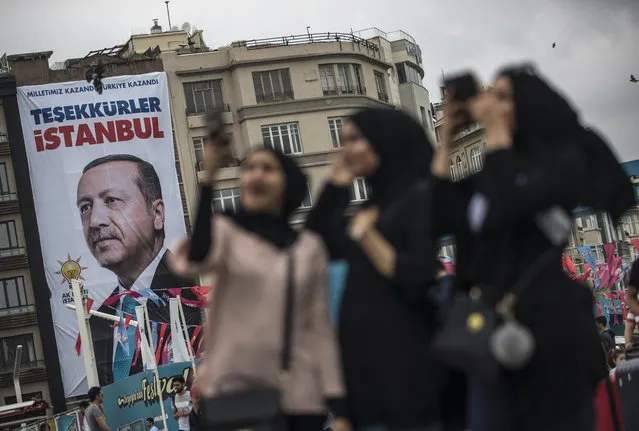 Muslim tourists pose in front of the poster of Turkish President Recep Tayyip Erdogan which reads, “Thank you Istanbul” at Taksim Square in Istanbul, Turkey, 26 June 2018. Turkish Electoral Commission on 26 June announced Recep Tayyip Erdogan has won the presidential elections. In the parliamentary elections, which were held at the same time as the presidential elections, although the Justice and Development Party (AKP) won with 42.5 percent of the votes, it lost the absolute majority which the party had secured in the parliament since 2002. (Photo by Sedat Suna/EPA/EFE)