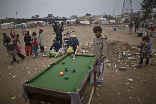 Pakistani boys plays snooker for 10 Rupees (U.S. 10 cents) per game, in a slum in Rawalpindi, Pakistan, Friday, January 23, 2015. (Photo by Muhammed Muheisen/AP Photo)