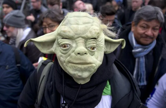 A queuing fan wearing a Yoda mask poses ahead of the European Premiere of “Star Wars The Force Awakens” in central London on December 16, 2015. Ever since 1977, when “Star Wars” introduced the world to The Force, Jedi knights, Darth Vader, Wookiees and clever droids R2-D2 and C3PO, the sci-fi saga has built a devoted global fan base that spans the generations. (Photo by Justin Tallis/AFP Photo)