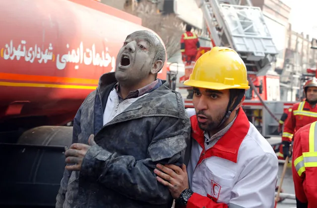 Rescue workers help an injured man in front of the collapsed iconic Plasco building in Tehran, Iran, 19 January 2017. Media reported that the major Plasco commercial building in Tehran has collapsed after hours of a severe fire, according to Iranian state media. At least 30 firefighters have died after being trapped on the upper floors of the building. (Photo by Abedin Taherkenareh/EPA/EFE)