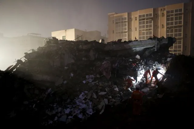 Firefighters use flashlights to search for survivors among the rubble of collapsed buildings after a landslide hit an industrial park in Shenzhen, Guangdong province, China December 20, 2015. (Photo by Tyrone Siu/Reuters)