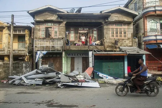 A local rides motorbike past damaged buildings after Cyclone Mocha in Sittwe township, Rakhine State, Myanmar, Monday, May 15, 2023. Rescuers on Monday evacuated about 1,000 people trapped by seawater 3.6 meters (12 feet) deep along western Myanmar's coast after the powerful cyclone injured hundreds and cut off communications. (Photo by AP Photo/Stringer)