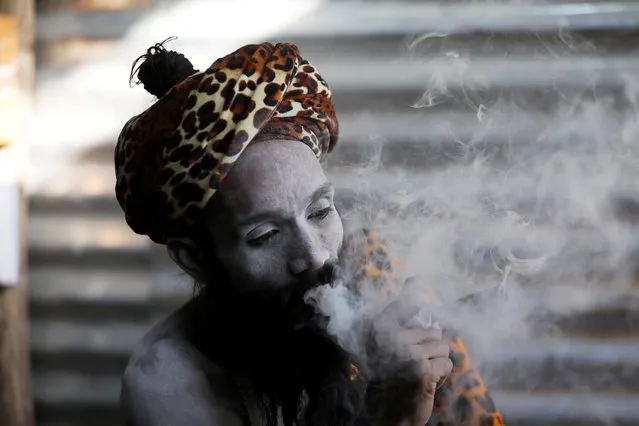 A Sadhu or Hindu holy man smokes inside his tent ahead of the first Shahi Snan at “Kumbh Mela” or the Pitcher Festival, in Haridwar, India, March 10, 2021. (Photo by Anushree Fadnavis/Reuters)