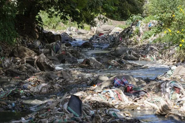 A tributary of the Nairobi River, which traverses informal settlements and industrial hubs, is seen full of garbage in Nairobi, Kenya, Wednesday, January 11, 2023. As clean water runs short, one of Africa's fastest growing cities is struggling to balance the needs of creating jobs and protecting the environment, and the population of over 4 million feels the strain. (Photo by Khalil Senosi)/AP Photo