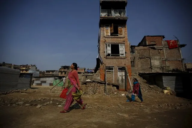Women walk past houses that were damaged by an earthquake earlier this year, in Bhaktapur, Nepal November 19, 2015. (Photo by Navesh Chitrakar/Reuters)