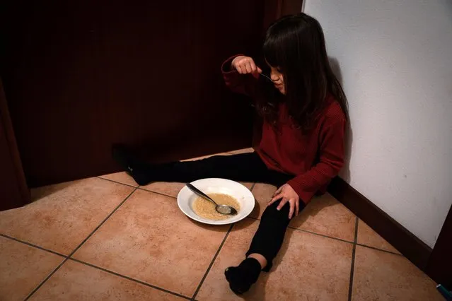 Bianca Toniolo, 3, eats dinner with her mother, Chiara Zuddas, who is self-isolating in her bedroom on the other side of the door after having contact with someone with coronavirus, in this picture taken by Bianca's father, who is also in quarantine at home with his family in San Fiorano, Italy, February 9, 2021. (Photo by Marzio Toniolo/Reuters)