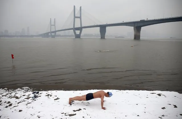 A winter swimmer does push-ups on the snow-covered banks of the Yangtze River, in Wuhan, Hubei province January 29, 2015. (Photo by Reuters/Stringer)