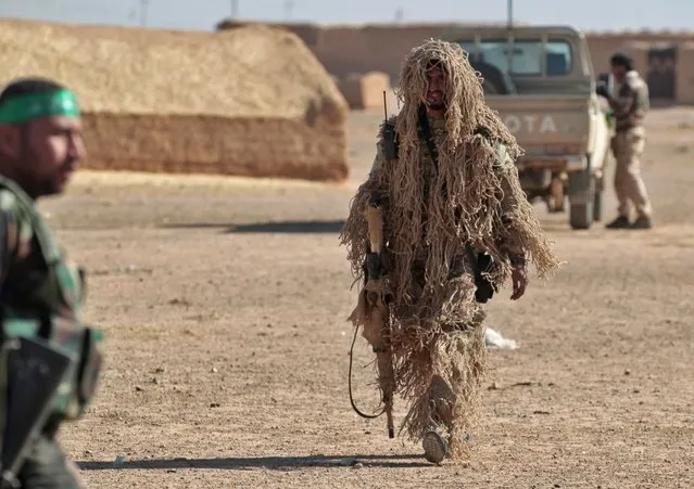 A camouflaged Iraqi sniper walks near the village of al-Tofaha, Iraq, November 25, 2016, during an ongoing operation against the Islamic State. (Photo by Ahmed Al-Rubaye/AFP Photo)