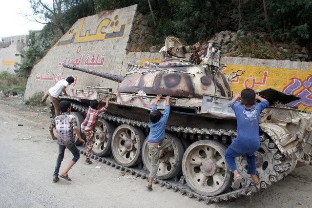 Boys climb on a tank used by pro-government fighters during recent battles against Houthi fighters in the southwestern city of Taiz, Yemen November 26, 2016. (Photo by Anees Mahyoub/Reuters)