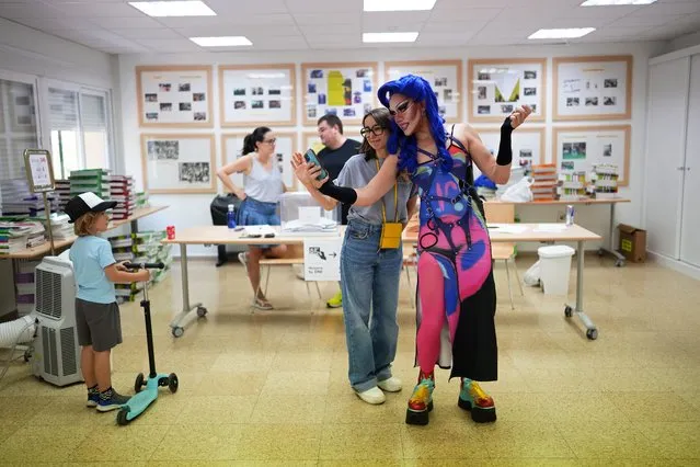 A voter poses for a selfie with Onyx, right, a drag queen doing election work at a polling station for Spain's general election, in Madrid, Sunday, July 23, 2023. Sunday's election could make the country the latest European Union member to swing to the populist right, a shift that would represent a major upheaval after five years under a left-wing government. (Photo by Manu Fernandez/AP Photo)