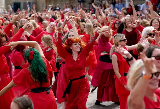 People dressed in red take part in a mass dance event to Kate Bush's Wuthering Heights as part of the Most Wuthering Heights Day Ever, in Folkestone harbour, Kent, UK on Sunday, July 30, 2023. (Photo by Gareth Fuller/PA Images via Getty Images)