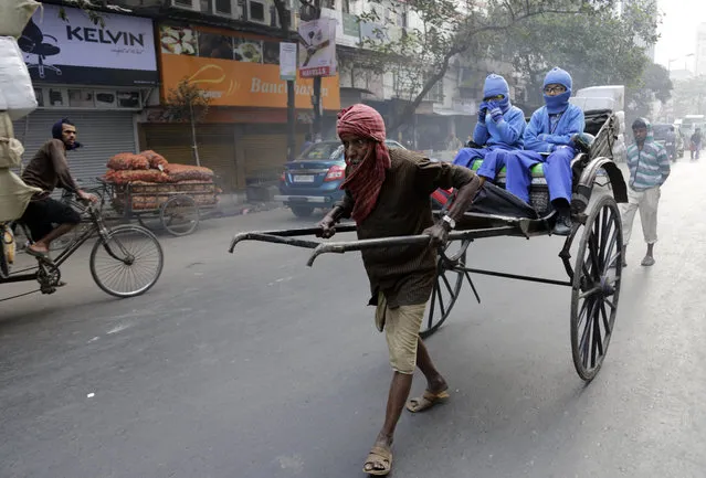 An Indian hand rickshaw puller transports children to school in Kolkata, India, Tuesday, February 10, 2015. Kolkata is the only city in India where hand-pulled rickshaws are still in operation. (Photo by Bikas Das/AP Photo)