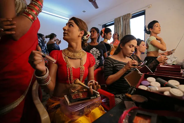 Transgender women apply make-up as they get ready backstage to perform during an event to raise funds for their community in Mumbai, September 20, 2018. (Photo by Francis Mascarenhas/Reuters)