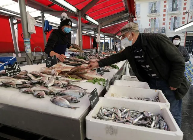 A man, wearing a protective face mask, shops at a fishmonger at a local market in Nice amid the coronavirus disease (COVID-19) outbreak in France, February 18, 2021. (Photo by Eric Gaillard/Reuters)