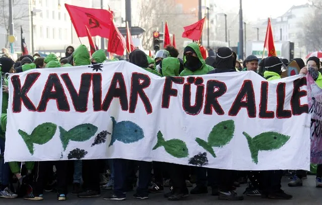Anti-capitalist protesters hold a banner reading “Caviar for all” near the European Central Bank (ECB) building before the official opening of its new headquarters in Frankfurt March 18, 2015. (Photo by Kai Pfaffenbach/Reuters)