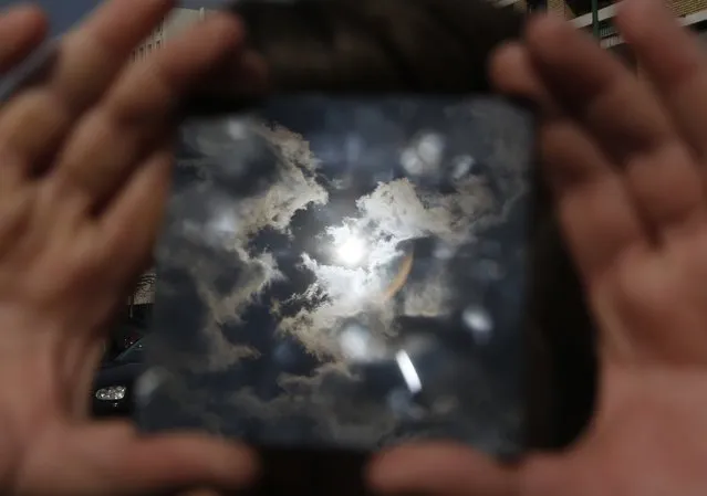 A solar eclipse is seen through a dark glass plate in Sarajevo, Bosnia, on Friday , March 20, 2015. Solar eclipse is darkening parts of Europe on Friday in a rare solar event that won't be repeated for more than a decade. (Photo by Amel Emric/AP Photo)