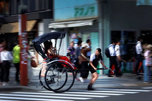 Rickshaw puller Akina Suzuki, 19, drives a rickshaw around Asakusa district in Tokyo, Japan on June 18, 2023. (Photo by Issei Kato/Reuters)