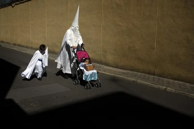 Penitents from the La Paz brotherhood walk to the church to take part in a procession in Seville, Spain, Sunday, March 29, 2015. (Photo by Emilio Morenatti/AP Photo)
