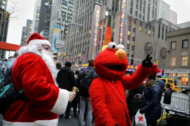 People dressed as Santa and Elmo stand on Sixth Avenue near Radio City in Manhattan, New York City, U.S. December 21, 2016. (Photo by Kevin Coombs/Reuters)