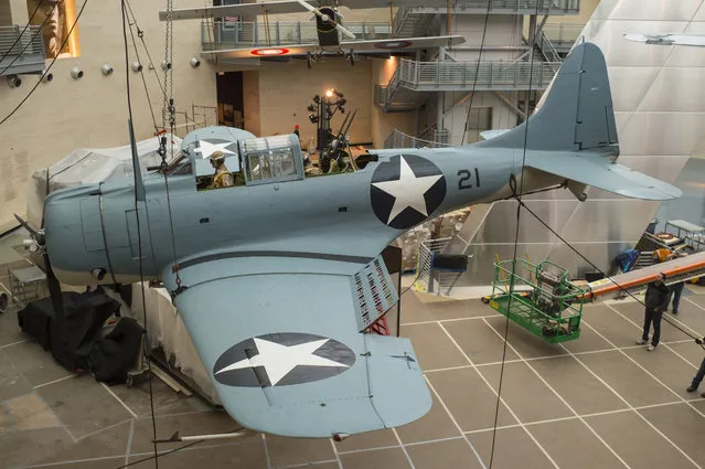A WWII dive bomber SBD Dauntless  with its sleek lines and immobile fighter pilot is positioned to be installed at the National Museum of the Marine Corps in Triangle, Virginia, on Tuesday, February 9, 2016. The SBD-3 was lost in a training accident and sank to the bottom of Lake Michigan. (Photo by Nikki Kahn/The Washington Post)