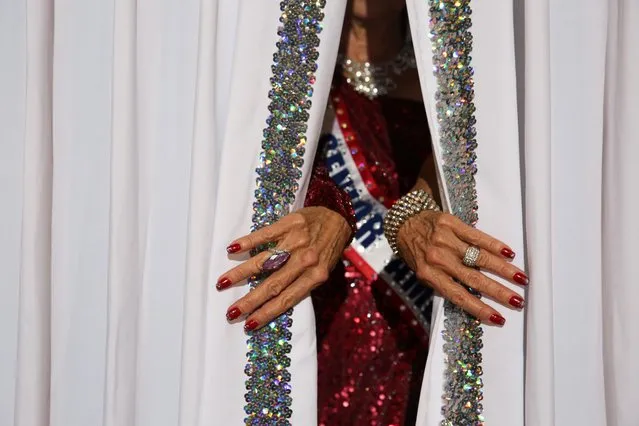 Debbie Carroll Boyce, Ms. Senior America 2011, pulls back the curtains on the stage at the Ms. Texas Senior America Pageant in Dallas, Texas, U.S., July 24, 2021. (Photo by Shelby Tauber/Reuters)