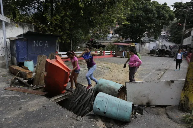 Roadblocks set up by anti-government protesters block a street in the Cotiza neighborhood during clashes with security forces as some residents show support for a mutiny by a National Guard unit in Caracas, Venezuela, Monday, January 21, 2019. Venezuela's government said Monday it put down the mutiny. (Photo by Fernando Llano/AP Photo)