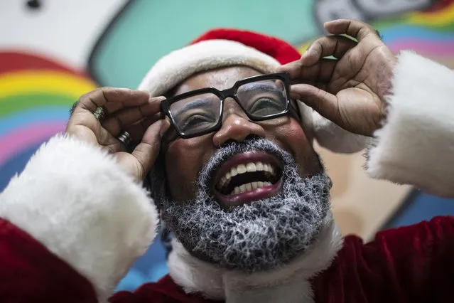 Actor Rodrigo Franca gets dressed up as "Papai Negro" or Black Santa, for a school Christmas event organized by the Favela Mundo NGO in the City of God favela in Rio de Janeiro, Brazil, Monday, December 11, 2023. In recent years Black Santas have been introduced to children in favelas to better reflect their cultural reality. (Photo by Bruna Prado/AP Photo)