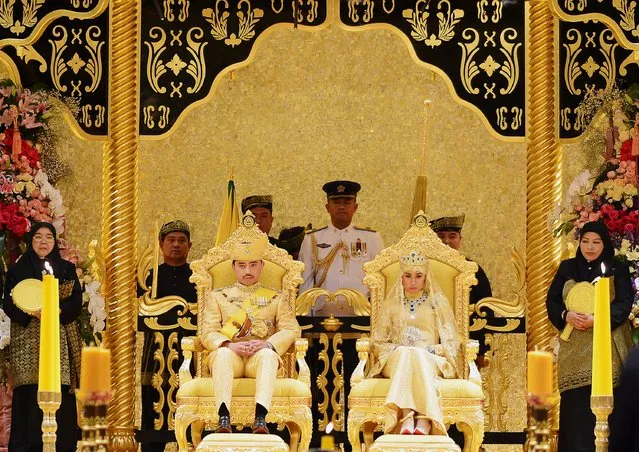 Brunei's newly wed royal couple, Prince Abdul Malik and Dayangku Raabi'atul 'Adawiyyah Pengiran Haji Bolkiah, sit during the “bersanding” or enthronement ceremony at their wedding in the Nurul Iman Palace in Bandar Seri Begawan April 12, 2015. (Photo by Olivia Harris/Reuters)
