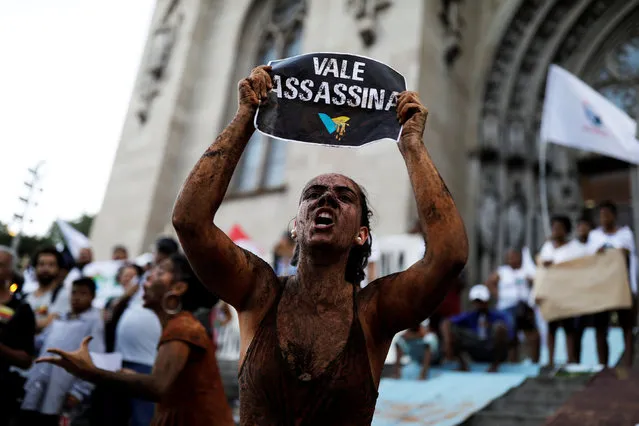 An activist covered in mud, holds a sign reading “VALE SA, Killer!”  during a protest against the Brazilian mining company Vale SA, in front of the Se Cathedral in Sao Paulo, Brazil, February 1, 2019. (Photo by Nacho Doce/Reuters)