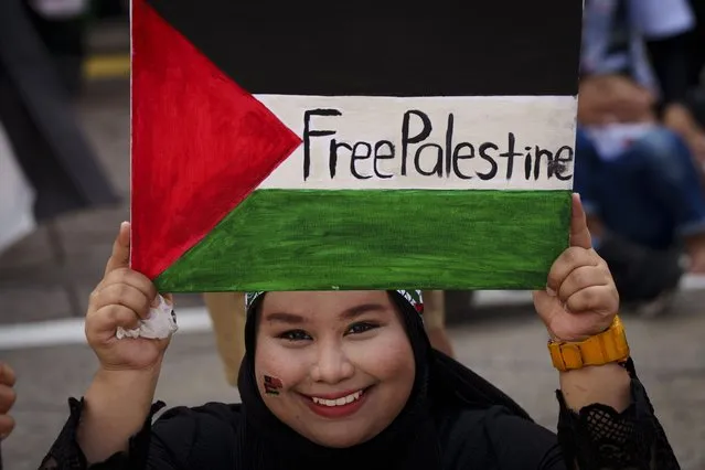 A Malaysian Muslim holds a poster representing the Palestinian flag during a rally to show her support for Palestinian people at Independence Square in Kuala Lumpur, Malaysia, Sunday, October 22, 2023. (Photo by Vincent Thian/AP Photo)