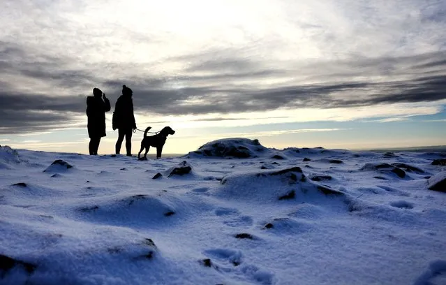 People walk a dog near Mow Cop Castle in Mow Cop, Staffordshire, Britain on January 16, 2024. (Photo by Carl Recine/Reuters)