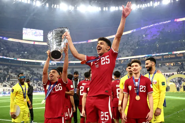 Khaled Mohammed and Ahmed Al Ganehi of Qatar lift the AFC Asian Cup trophy after their team's victory in the AFC Asian Cup final match between Jordan and Qatar at Lusail Stadium on February 10, 2024 in Lusail City, Qatar. (Photo by Robert Cianflone/Getty Images)