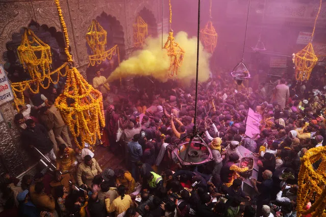 A priest (L) throws coloured powder over Hindu devotees during “Basant Panchami” festival celebrations, which mark the preparations for the arrival of spring, inside the Sri Bankey Bihari temple in Vrindavan on February 14, 2024. (Photo by AFP Photo)