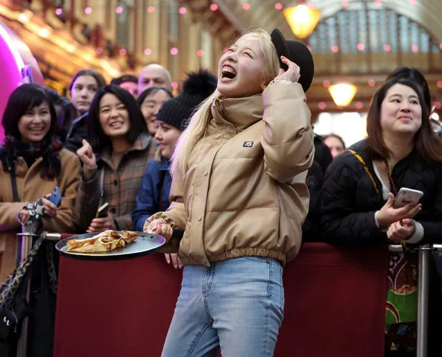 A competitor reacts during the Shrove Tuesday Pancake Race at the City of London's Leadenhall Market on February 13, 2024. (Photo by Isabel Infantes/Reuters)