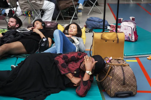 Passengers arrive at a gym in the village of Zaventem which became a crisis center set up by the red cross and a place where stranded passengers can find their relatives after twin blasts rocked the main terminal of Brussels airport on March 22, 2016. (Photo by Tim Dirven/The Washington Post)
