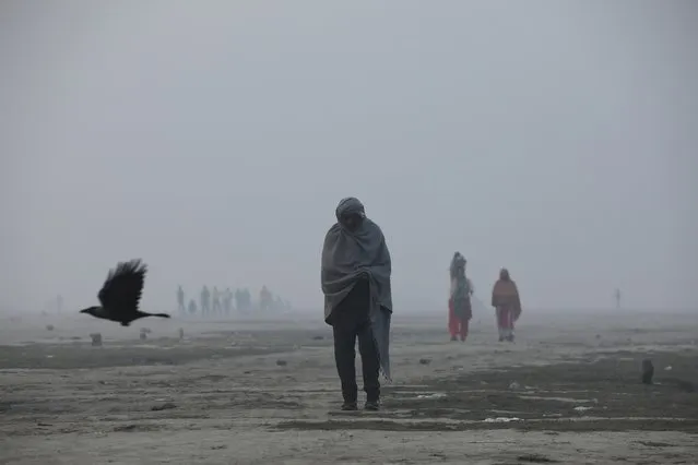 People are seen on the floodplains of the Yamuna river on a smoggy morning in New Delhi, India, November 17, 2021. India’s Supreme Court has ordered people in New Delhi and surrounding regions to work from home over pollution concerns. (Photo by Anushree Fadnavis/Reuters)