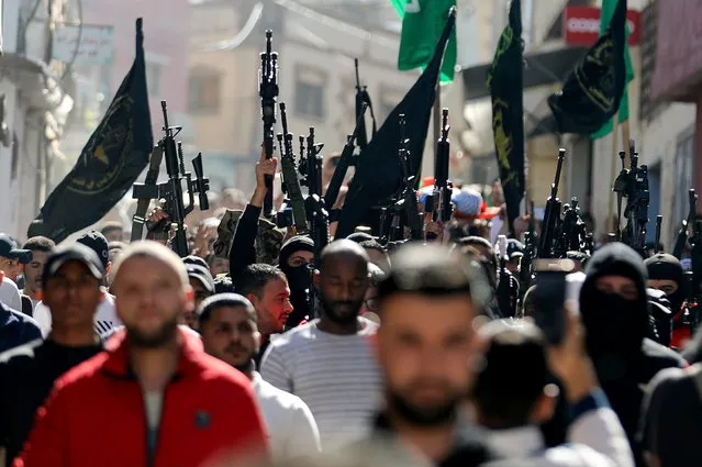 Mourners and militants take part in the funeral of Palestinian boy Mohamed Dadis, who the Palestinian health ministry said was killed by Israeli forces during clashes, in Nablus, in the Israeli occupied West Bank on November 6, 2021. (Photo by Raneen Sawafta/Reuters)