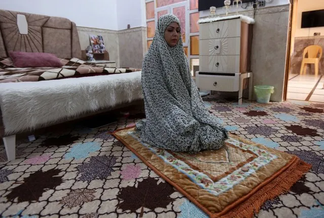 Bushra Abdul Zahra, a 36-year-old Iraqi local boxing and karate practitioner, prays at her home in Najaf, Iraq on December 24, 2021. (Photo by Alaa Al-Marjani/Reuters)