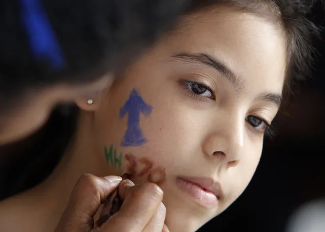 A girl has her face painted during the Day of Remembrance for MH370 event in Kuala Lumpur, Malaysia on Saturday, March 4, 2017. After three years, the hunt for Malaysia Airlines Flight 370 ended in futility and frustration Tuesday, Jan. 17, 2017, as crews completed their deep-sea search of a desolate stretch of the Indian Ocean without finding a single trace of the plane. (Photo by Daniel Chan/AP Photo)